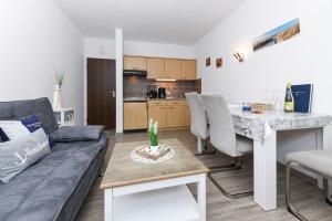 a living room with a couch and a table at Ferienwohnungen Haus Boje "Scholle" in Neuharlingersiel +16 photos