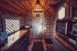 a kitchen with a door and a stone wall at The Wizards Cauldron -Harry Potter Themed in Lewannick