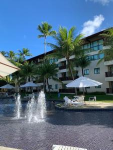 einen Brunnen vor einem Hotel mit Palmen in der Unterkunft Marulhos Resort by HomeTemp in Porto De Galinhas