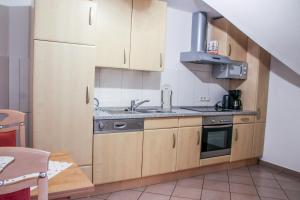 a kitchen with wooden cabinets and a sink at Familienhof Brüning - Gartenblick in Meppen