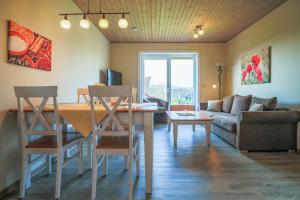 a living room with a table and chairs and a couch at Ferienhof Büdlfarm - Haus in Fehmarn