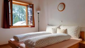 a bedroom with a large bed with a window at Gasthaus Alpenrose in Innerferrera