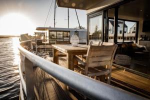 een tafel en stoelen op een boot in het water bij Hausboot freiZeit - LP4 in Peenemünde
