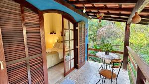 a balcony of a house with a table and chairs at Janela dos Meus Sonhos in Penedo