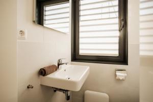 een witte wastafel in een badkamer met een raam bij Hausboot freiZeit - LP4 in Peenemünde