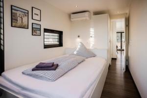 een groot wit bed in een witte kamer met: bij Hausboot freiZeit - LP4 in Peenemünde +17 foto's