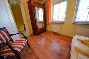 una camera con sedia e pavimenti e finestre in legno di Sonnenkliff OG a Groß Zicker