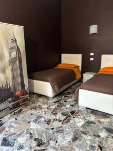 a bedroom with two beds and a painting of big ben at B&B AFFITTACAMERE Mo' MONTEIASI in Monteiasi