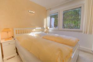 une chambre avec un grand lit avec une fenêtre dans l'établissement Windeby 4T, à Wenningstedt
