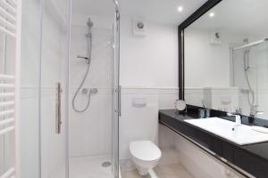 une salle de bain avec une douche, des toilettes et un lavabo dans l'établissement Windeby 4T, à Wenningstedt