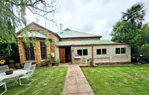 a house with a green roof and a yard at Roes se Moes in Kestell