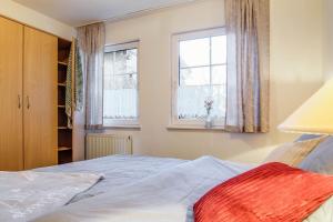 Un dormitorio con una cama y dos ventanas. en Stürmann, en Prerow