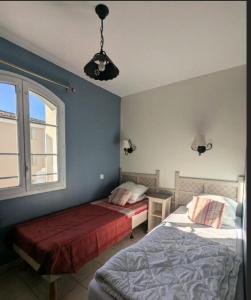 une chambre avec deux lits et une fenêtre dans l'établissement Les Coteaux de Pont Royal en Provence - maeva Home - Appartement 3 pièces 6 personnes - Sélection MAE-2554, à Mallemort