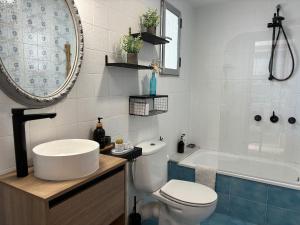 a bathroom with a toilet and a sink and a tub at Parking Privado l Terraza Relajante Junto Al Mar in Tavernes de Valldigna +13 photos