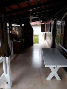 a white bench sitting in the middle of a patio at Casa de Praia Aconchegante in Bertioga
