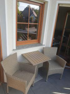 a picnic table and two chairs on a porch at FeWo im Lippischen Bergland in Kalletal