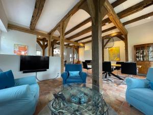 a living room with blue couches and a flat screen tv at Ferienhaus am Wasserschloss Haus Marck in Tecklenburg