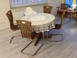 a table with wicker chairs and a table with a white table cloth at Ferienwohnung an der Mosel, Julia in Senheim