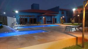 a house with a swimming pool at night at Pousada Lençóis Eco Villa in Santo Amaro