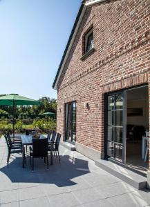 un patio con tavolo e sedie e un edificio in mattoni di Ostseehaus 1 a Westermarkelsdorf