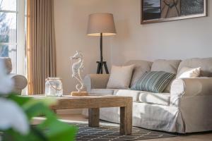 un soggiorno con un divano e un tavolo di Ostseehaus 1 a Westermarkelsdorf Altre 16 foto