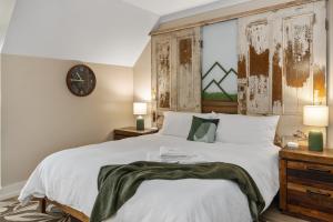 赛维尔维尔3 King Bd with Hot Tub & Minutes to Dollywood!的卧室里有一张床，墙上挂着一个钟