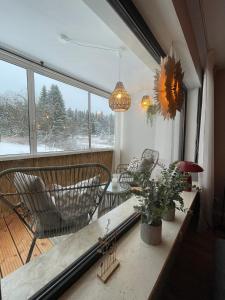 a room with chairs and a table and a large window at Ferienwohnung Harzallerliebst Hahnenklee in Goslar
