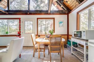 a kitchen with a table and chairs and windows at Serene Lakes Cabin with Deck Dog Friendly! in Soda Springs