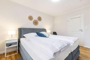 ein Schlafzimmer mit einem großen weißen Bett und einem Fenster in der Unterkunft Ferienhof Marquardt Bungalow 2 in Fehmarn