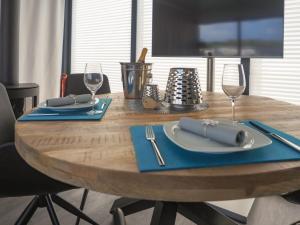 a wooden table with blue napkins and silverware on it at Hausboot Krosse Krabbe - LP6 in Peenemünde
