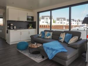 a living room with a couch and a kitchen at Hausboot Krosse Krabbe - LP6 in Peenemünde +10 photos