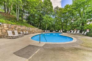 a swimming pool with chairs and a stone wall at Spacious Mountain-View Home 13 Mi to GSMNP! in Gatlinburg