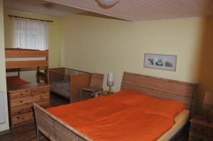 a bedroom with a bed with an orange blanket at Ferienhof Kruse Wohnung 8 in Grömitz