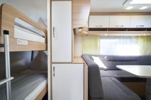 a small living room with a couch and a kitchen at Camper Lodge CL1 in Hindenberg