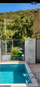 a swimming pool with a view of a house at Villa Darius in Cabo Frio