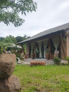 a house with a porch with curtains on it at Canto do Beija-flor Rolante RS in Rolante