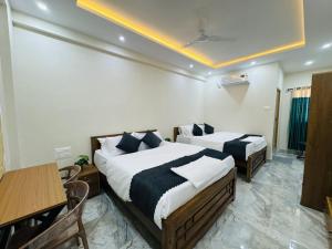 a hotel room with two beds and a table at Thamarassery INN luxury and budget Rooms in Thamarassery
