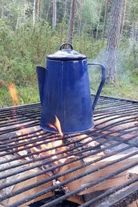a blue kettle sitting on top of a grill at Woxy Lilaloppan - privacy, space and nature in Voxnabruk