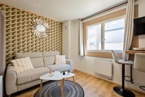 a living room with a couch and a table at Le Sublime-100m de la plage-Cozy-Refait à Neuf ! in Canet-en-Roussillon