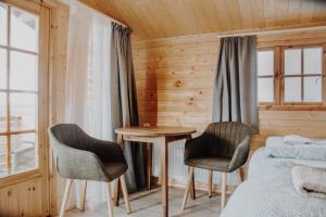 a bedroom with a bed and two chairs and a table at Rauðuskriður in Hvolsvöllur