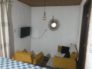 a living room with two yellow chairs and a mirror at Casa Jasmim in Imbituba