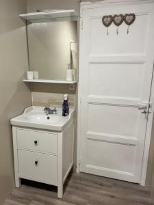 a bathroom with a white door and a sink at Fair Field in Sourdeval +8 photos