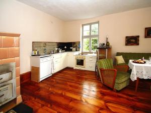 プラウ・アム・ゼーにあるFerienwohnung, Plau am Seeのウッドフロアのキッチン(テーブル、椅子付)