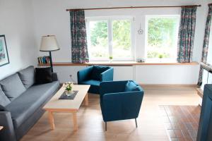 a living room with a couch and two chairs and a table at Landhaus Seeblick in Bitburg
