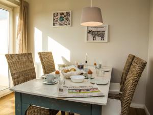 ein Esstisch mit Stühlen und ein Tisch mit einer Lampe in der Unterkunft FerienDüne 8 in Kägsdorf