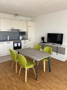 a kitchen with a table and green chairs at Appartement 24 in Oerlinghausen +13 photos