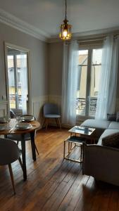 una sala de estar con un sofá y una mesa en Paris La défense, en La Garenne-Colombes