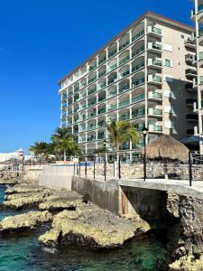 un edificio sulla spiaggia con ponte e acqua di The Queen of Cozumel - ROYAL VISTA - Caribbean Ocean VIEW Suite for Couples in Mind a Cozumel