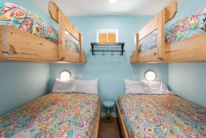 deux lits dans une chambre aux murs bleus dans l'établissement Mermaid Cove PA - Beach Gear Credit Included, à Fresno 52 autres photos