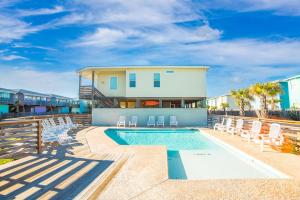 une piscine avec des chaises et une maison dans l'établissement Mermaid Cove PA - Beach Gear Credit Included, à Fresno